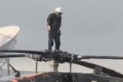 海外「ヘリコプターのプロペラの上に乗る男」
