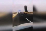 迫る道路標識！荷台を上げたまま走行する大型ダンプ