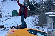 危険よりも記録。自分の車が凍った川に沈む瞬間、屋根に上って自撮りする女性