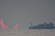 海面から突き出た巨大な赤い角。「悪魔の角」と呼ばれる気象現象が確認される（カタール）