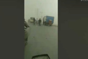 砂塵嵐のなかを進むバイク乗り in パキスタン