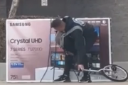 電気屋で購入した75インチのテレビを背負って一輪車で帰る人