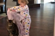 赤ちゃんのイタズラを受け入れる猫「もう…これが我輩の人生なのだ」